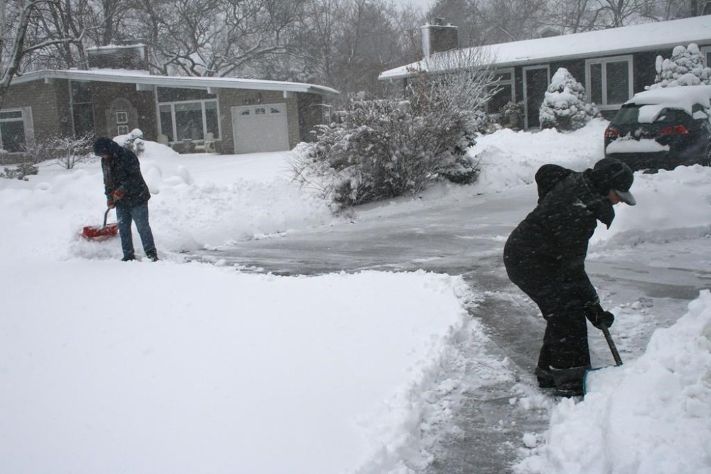 Two women shovel heavy snow in Oakville, Ont., on Friday, March 10, 2023. Southern Ontario is being hit with another winter storm that's causing slippery road conditions, crashes and transit cancellations. THE CANADIAN PRESS/Richard Buchan