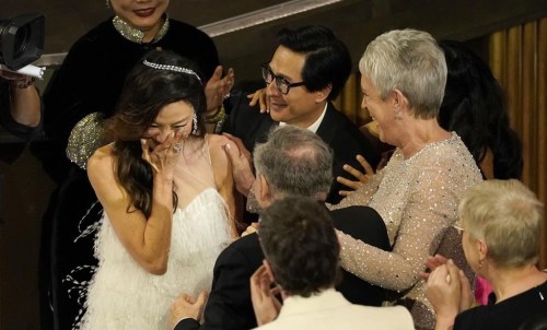 Michelle Yeoh, left, reacts in the audience with excitement as she accepts the award for best performance by an actress in a leading role for 