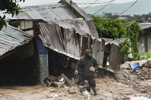 A man stands outside his damaged home in Blantyre, Malawi, Monday, March 13, 2023. An unrelenting Cyclone Freddy that is currently battering southern Africa has killed at least 56 people in Malawi and Mozambique since it struck the continent for a second time on Saturday night, authorities in both countries have confirmed. (AP Photo/Thoko Chikondi)