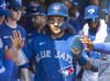 Toronto Blue Jays' Bo Bichette greeted by teammates in the dugout after scoring against the Philadelphia Phillies in the first inning of their spring training game in Dunedin, Fla., Sunday, March 5, 2023. Bichette hit two homers and drove in four runs, Andres Sosa added a three-run shot and the Toronto Blue Jays thumped the Boston Red Sox 16-3 in spring training baseball action Monday.THE CANADIAN PRESS/Fred Thornhill