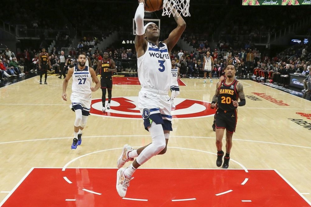 Minnesota Timberwolves forward Jaden McDaniels (3) dunks in the first half of an NBA basketball game against the Atlanta Hawks, Monday, March 13, 2023, in Atlanta. (AP Photo/Brett Davis)
