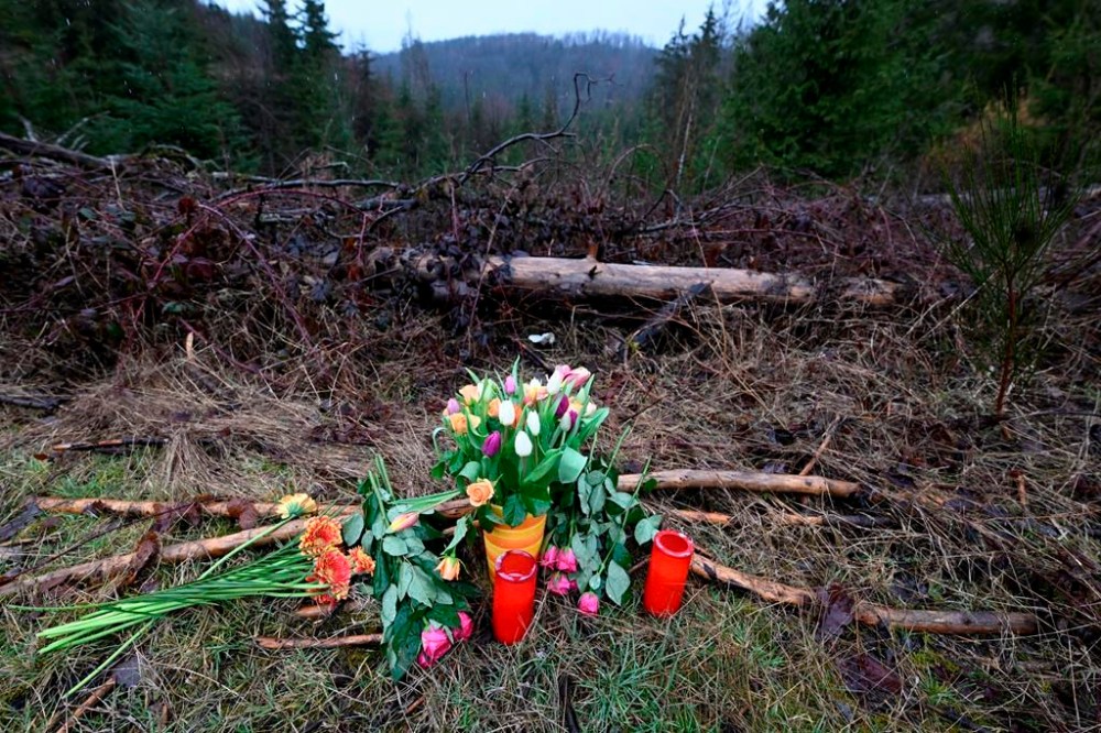 Flowers and candles are placed in a wooded area in Freudenberg, Germany, Tuesday, March 14, 2023 where the body of a 12-year-old girl was found on Sunday. The girl went missing on Saturday and the police launched a large-scale search operation, during which the body was discovered on Sunday. German police said Tuesday a 12-year-old girl, who was found dead earlier this week in the western German town of Freudenberg, was killed by two children. (Roberto Pfeil/dpa via AP)