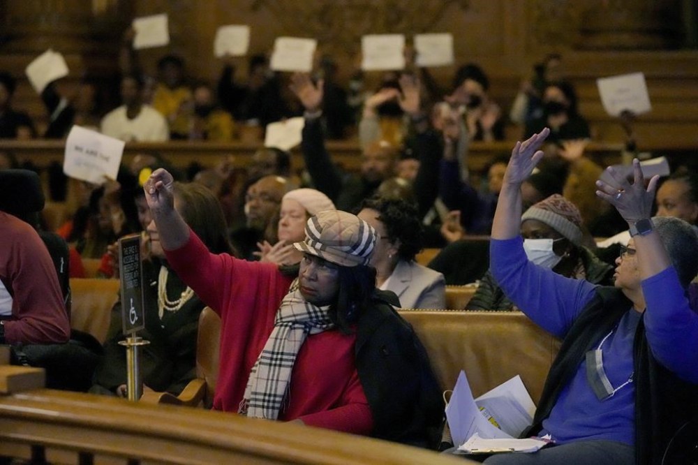 People react to speakers during a special Board of Supervisors hearing about reparations in San Francisco, Tuesday, March 14, 2023. Supervisors in San Francisco are taking up a draft reparations proposal that includes a $5 million lump-sum payment for every eligible Black person. (AP Photo/Jeff Chiu)