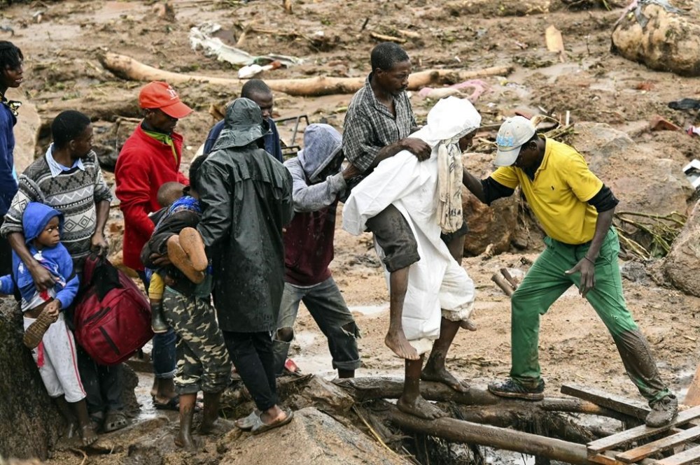 FILE - An injured man is helped across in Blantyre, Malawi, Monday, March 13, 2023. From devastating cyclones and floods to an unrelenting drought, African countries are spending between 2% and 9% of their budgets to respond to extreme weather events, according to a report released by the United Nations on Wednesday, March 15. (AP Photo/Thoko Chikondi, File)