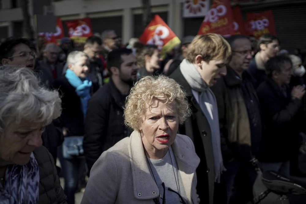 Protesters walk during a demonstration in Lyon, central France, Wednesday, March 15, 2023. Opponents of French President Emmanuel Macron's pension plan are staging a new round of strikes and protests as a joint committee of senators and lower-house lawmakers examines the contested bill. (AP Photo/Laurent Cipriani)