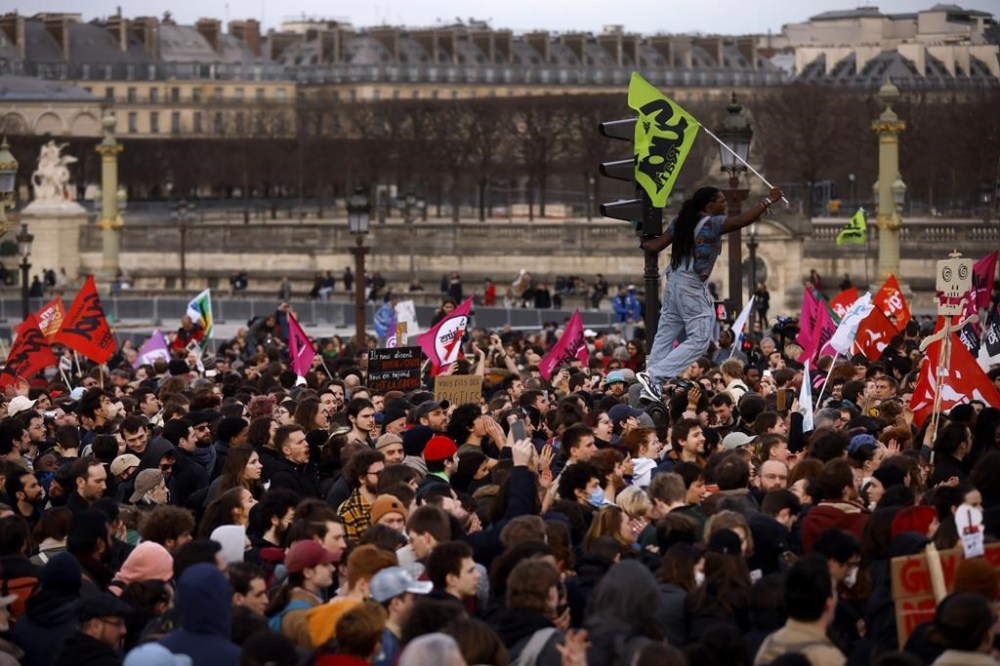 Protesters gather at Concorde square near the National Assembly in Paris, Thursday, March 16, 2023. French President Emmanuel Macron has shunned parliament and opted to push through a highly unpopular bill that would raise the retirement age from 62 to 64 by triggering a special constitutional power. (AP Photo/Thomas Padilla)