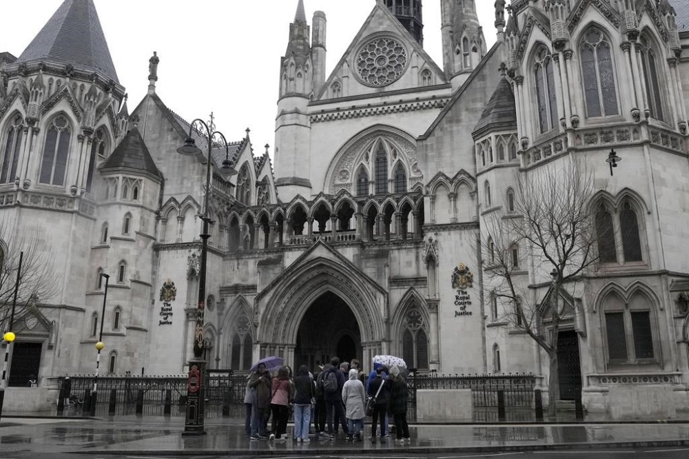 People stand outside the Royal Court of Justice in London, Friday, March 17, 2023. The Duke of Sussex, Prince Harry is suing Associated Newspapers Limited (ANL) over an article about his separate judicial review proceedings against the Home Office regarding security arrangements for himself and his family when they are in the UK. (AP Photo/Frank Augstein)