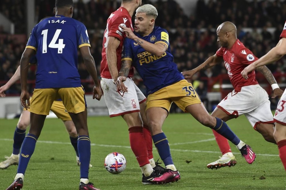 Newcastle's Bruno Guimaraes tries to break through Nottingham Forrest defence during the English Premier League soccer match between Nottingham Forest and Newcastle United at the City Ground stadium in Nottingham, England, Friday, March 17, 2023. (AP Photo/Rui Vieira)