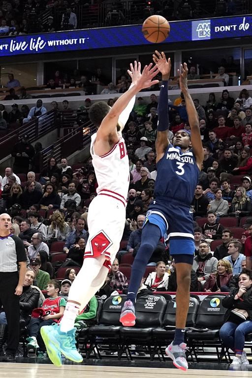 Minnesota Timberwolves forward Jaden McDaniels, right, shoots over Chicago Bulls guard Zach LaVine during the first half of an NBA basketball game in Chicago, Friday, March 17, 2023. (AP Photo/Nam Y. Huh)