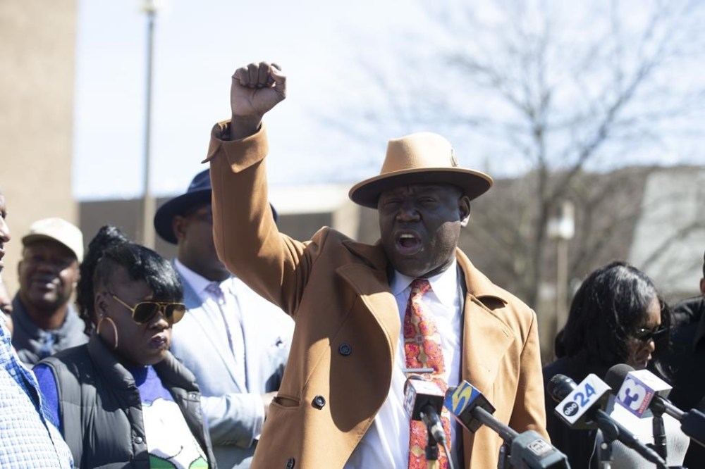 Attorney Ben Crump raises a fist and says