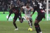 Udinese's Kingsley Ehizibue, center, fights for the ball with Milan's Fodé Ballo-Touré, left, during the Italian Serie A soccer match between Udinese Calcio and AC Milan at the Friuli stadium in Udine, Italy, Saturday, March 18, 2023. (Andrea Bressanutti/LaPresse via AP)