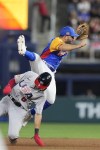 United States' Trea Turner (8) upends Venezuela second baseman Jose Altuve (27) as he slides into second during a double play in the second inning of a World Baseball Classic game, Saturday, March 18, 2023, in Miami. Mookie Betts was out at first. (AP Photo/Wilfredo Lee)