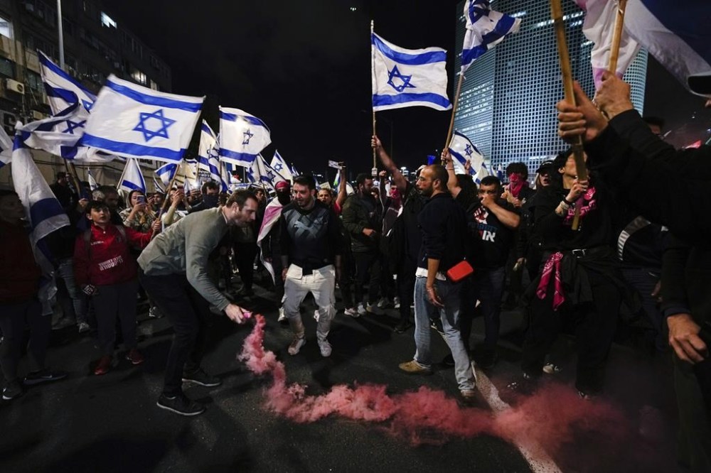 FILE - Demonstrators block highway during a protest against plans by Prime Minister Benjamin Netanyahu's government to overhaul the Israel's judicial system, in Tel Aviv, Israel, on March 18, 2023. Members of Netanyahu's coalition raced ahead with part of the overhaul — a new plan for appointing Supreme Court justices — before the parliament takes a monthlong holiday break next week. It pleged to then take up the rest of the planned overhaul, which critics say would roll back Israel's democratic checks and balances. The plans have sparked unprecedented protests in Israel over the past three months. (AP Photo/Ohad Zwigenberg, File)