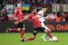 Bayern's Jamal Musiala, right, and Leverkusen's Kerem Demirbay, center, vie for the ball during the German Bundesliga soccer match between Bayer Leverkusen and Bayern Munich in Leverkusen, Germany, Sunday, March 19, 2023. (AP Photo/Martin Meissner)