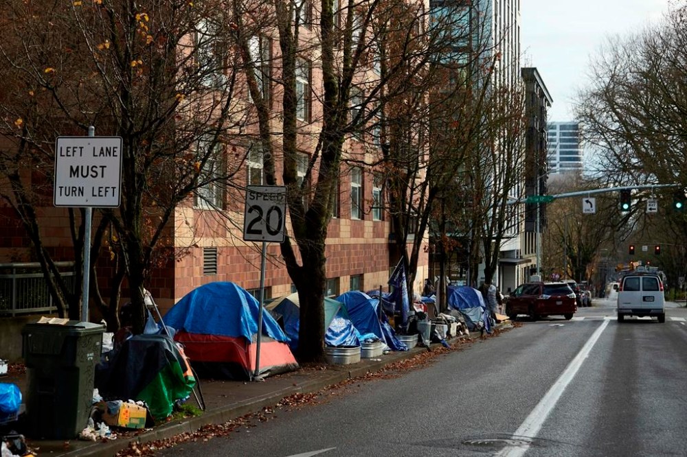 FILE - Tents line the sidewalk on SW Clay St in Portland, Ore., on Dec. 9, 2020. Oregon lawmakers are expected to approve $200 million in spending to tackle the state's homelessness and housing crises. The package will be voted on by the state Senate on Tuesday, March 21, 2023, after passing the House with bipartisan support. (AP Photo/Craig Mitchelldyer, File)