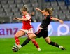Bayern's Klara Buhl, right, and Arsenal's Laura Wienroither battle for the ball during the women's Champions League first leg quarterfinal soccer match between Bayern Munich and Arsenal at Allianz Arena, Munich, Germany, Tuesday March 21, 2023. (Peter Kneffel/dpa via AP)