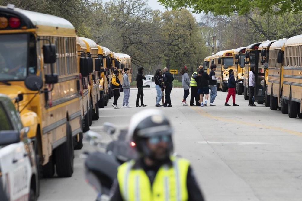 Arlington Police officers block a street as Lamar High School students and faculty are evacuated after a school shooting on Monday morning, March 20, 2023 in Arlington, Texas. (Ben Torres/The Dallas Morning News via AP)