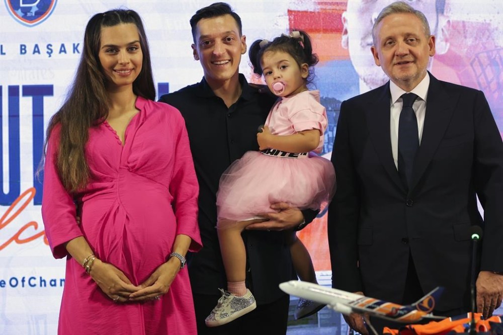 FILE - Istanbul Basaksehir's new signing Mesut Ozil, second left, poses for the media with his wife Amine Gulse Ozil, left, their daughter Eda and team's president Goksel Gumusdag during his official presentation in Istanbul, Turkey, Thursday, July 14, 2022. Former Germany midfielder Mesut Özil, who won the World Cup in 2014, retired from soccer Wednesday, March 22, 2023, at the age of 34. (AP Photo, File)