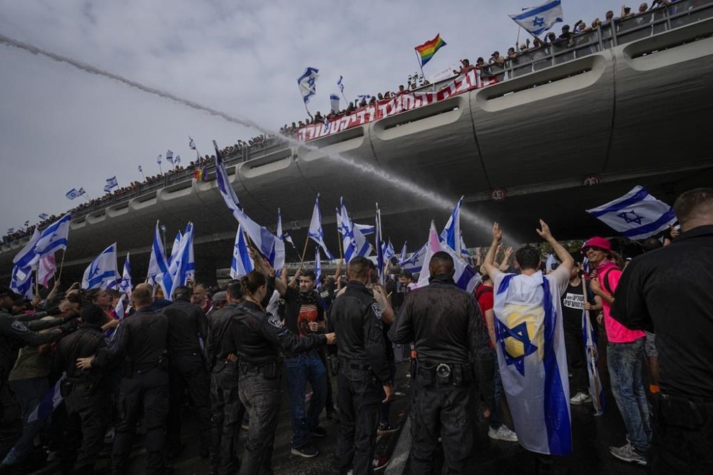 Israeli police use water cannon to disperse Israelis protest against plans by Prime Minister Benjamin Netanyahu's government to overhaul the judicial system in Tel Aviv, Israel, Thursday, March 23, 2023. (AP Photo/Ohad Zwigenberg)