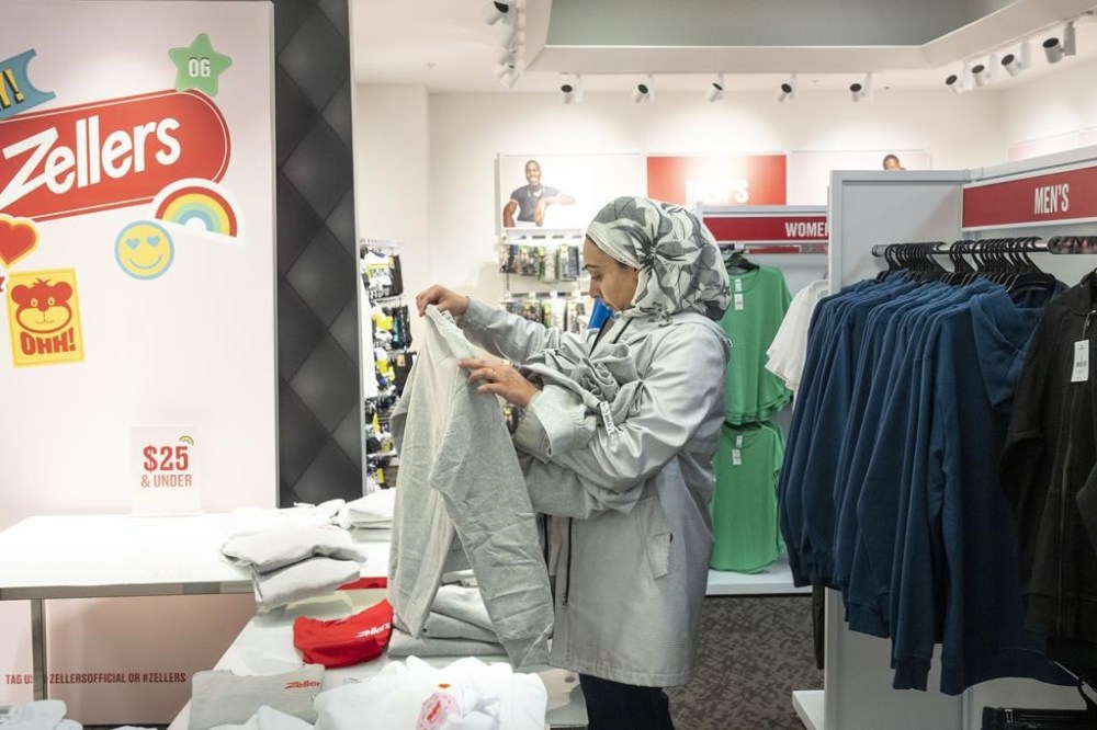 A shopper picks up an item at a newly-opened Zellers store in Scarborough Town Centre Mall, in Scarborough, Ont., on Thursday March 23, 2023. THE CANADIAN PRESS/Chris Young