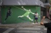 Fans pose for a photo next to a mural depicting the save by Emiliano 