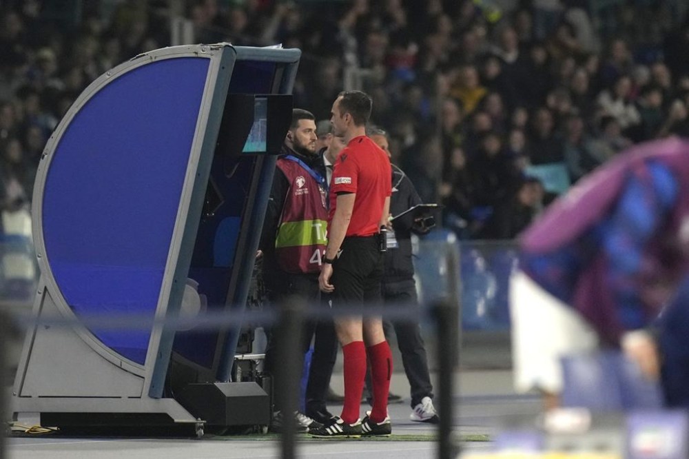 The referee checks a VAR monitor before awarding a penalty kick to England during the Euro 2024 group C qualifying soccer match between Italy and England at the Diego Armando Maradona stadium in Naples, Italy, Thursday, March 23, 2023. (AP Photo/Alessandra Tarantino)