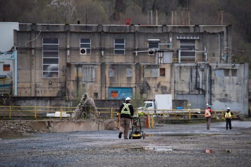 Workers walk towards a power plant used by a former pulp mill at the Woodfibre LNG project site near Squamish, B.C., on Friday November 4, 2016. THE CANADIAN PRESS/Darryl Dyck