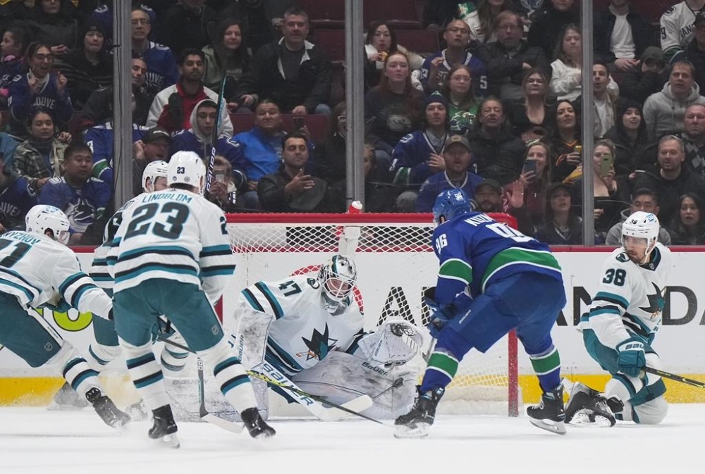 Vancouver Canucks' Andrei Kuzmenko (96) scores against San Jose Sharks goalie James Reimer (47) during the first period of an NHL hockey game in Vancouver, B.C., Thursday, March 23, 2023. THE CANADIAN PRESS/Darryl Dyck