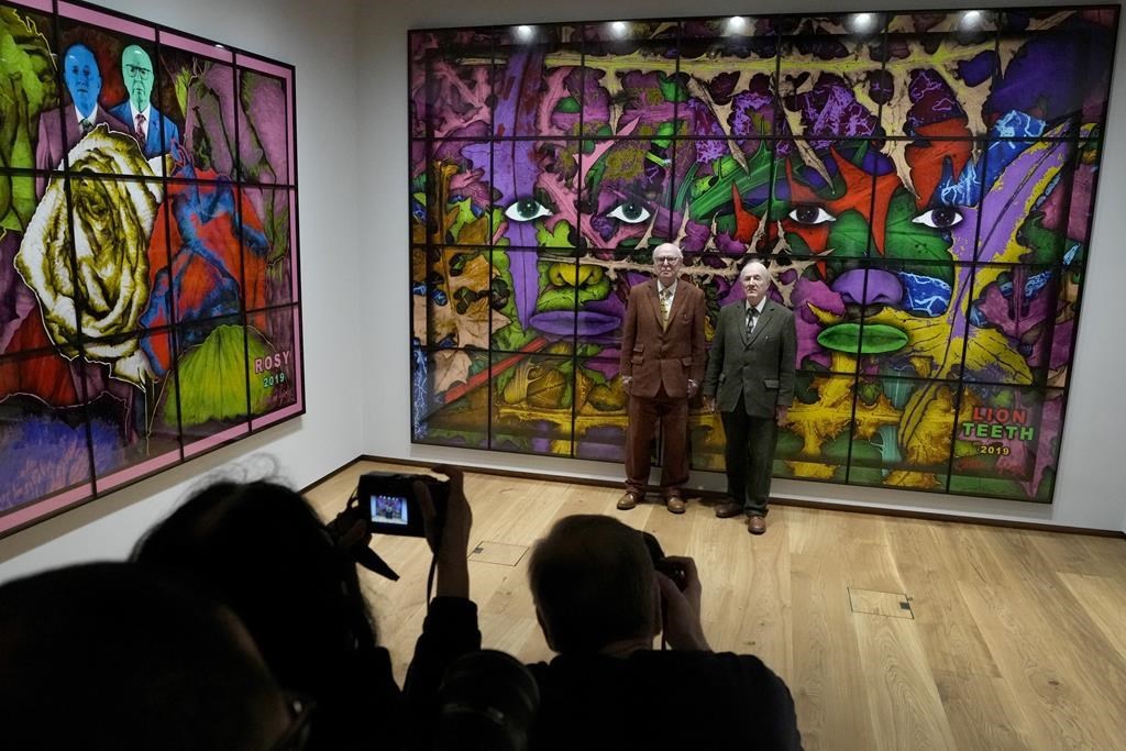 Gilbert and George are photographed with their artwork in their exhibition called The Paradisical Pictures at the opening of The Gilbert & George Centre in east London, Friday, March 24, 2023. (AP Photo/Kirsty Wigglesworth)
