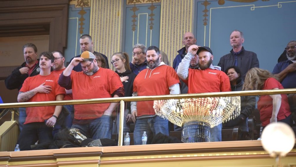 FILE - Union members, supporters and others put their hats back on after reciting the Pledge of Allegiance, Tuesday morning, March 14, 2023. Michigan, long known as a mainstay of organized labor, became the first state in decades to repeal a union-restricting law known as “right-to-work” that was passed over a decade ago by a Republican-controlled Legislature. (Todd McInturf/Detroit News via AP)