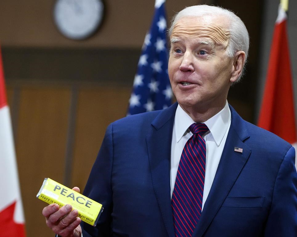 U.S. President Joe Biden holds a chocolate bar he received at a welcoming ceremony on Parliament Hill in Ottawa, on Friday, March 24, 2023. THE CANADIAN PRESS/Justin Tang