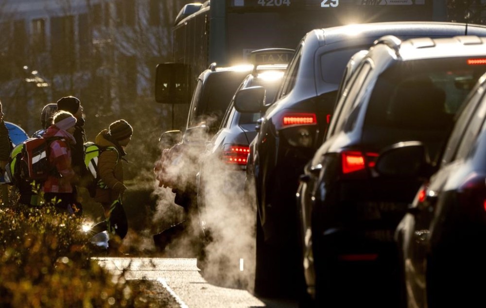 FILE - Cars give off exhaust fumes as children head to school in Frankfurt, Germany, on Monday, Feb. 27, 2023. Germany and the European Union said Saturday, March 25, 2023 that they reached an agreement in their dispute over the future of cars with combustion engines allowing the registration of new vehicles with combustion engines even after 2035 if they use climate-neutral fuel only. (AP Photo/Michael Probst, File)