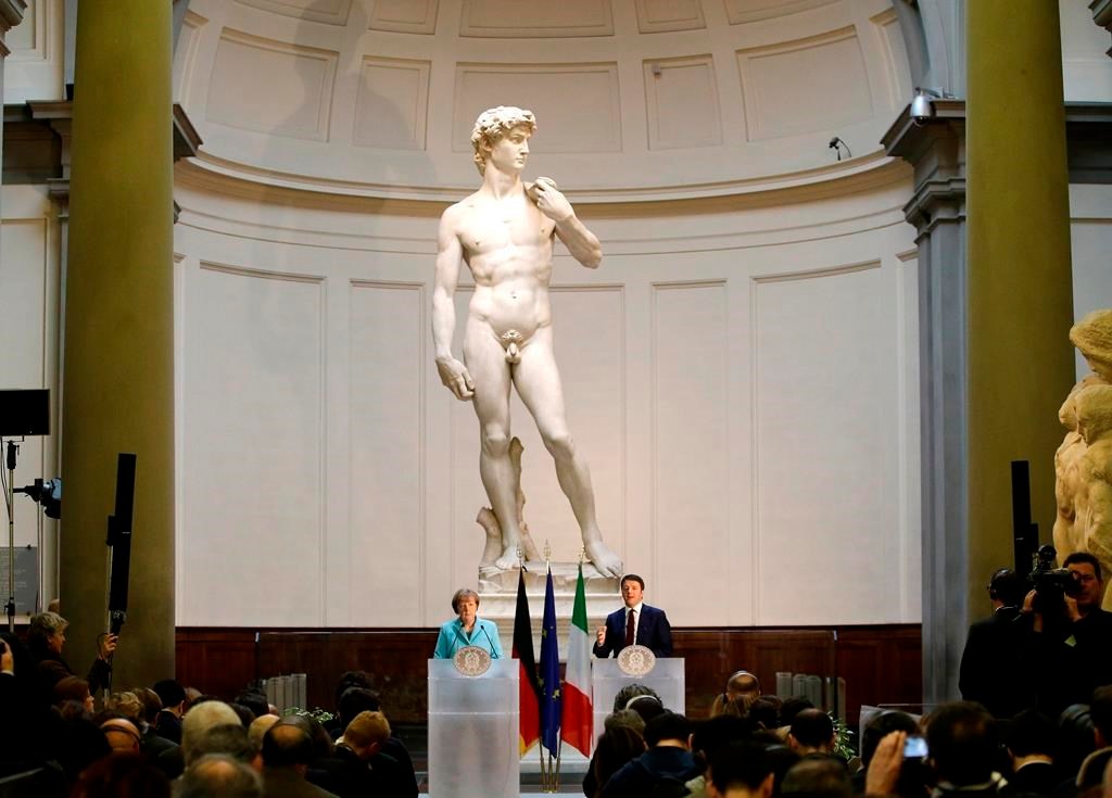 FILE - German Chancellor Angela Merkel, left, and Italian Prime Minister Matteo Renzi speak during a press conference in front of Michelangelo's 