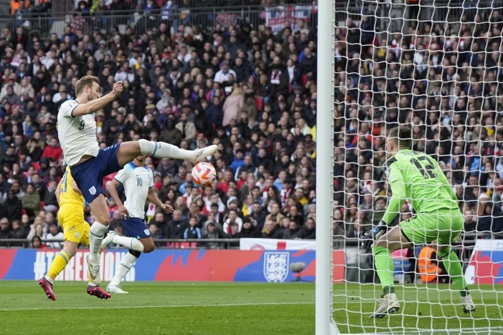 Englands' Harry Kane, left, makes an attempt to score past Ukraine's goalkeeper Anatoliy Trubin during the Euro 2024 group C qualifying soccer match between England and Ukraine at Wembley Stadium in London, Sunday, March 26, 2023. (AP Photo/Alastair Grant)