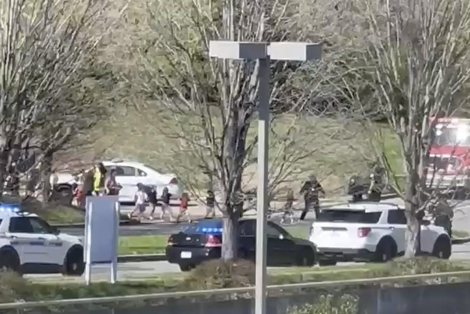 In this image from video provided by Jozen Reodica, law enforcement officers lead children away from the scene of a shooting at The Covenant School, a private Christian school in Nashville, Tenn., on Monday March 27, 2023. (Jozen Reodica via AP)