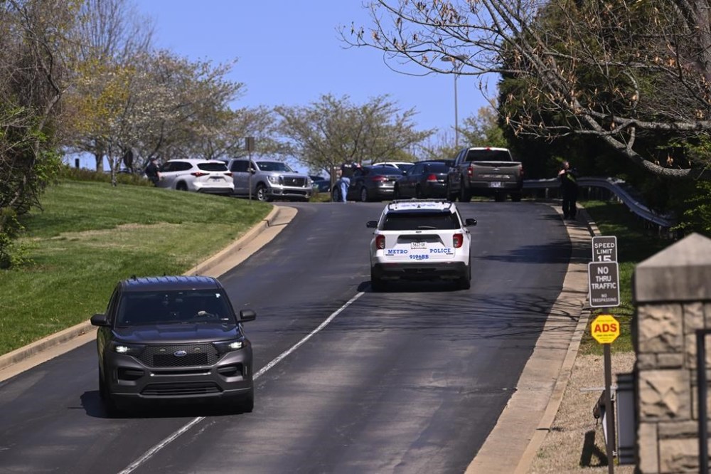 Police vehicles are seen on a drive way beteen the front entrance and Covenant School in Nashville, Tenn. Monday, March 27, 2023. Officials say several children were killed in a shooting at the private Christian grade school in Nashville. The suspect is dead after a confrontation with police. (AP Photo/John Amis)