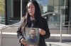 Ashbey Beasley holds a photo of murder victim Eduardo Uvaldo outside of the Lake County Courthouse following a hearing for Robert E. Crimo III, who is accused of murder in the Highland Park Fourth of July shootings, on Nov. 1, 2022, in Waukegan, Ill. Beasley, who has been pushing Congress to pass a ban on semiautomatic weapons, rushed to the scene of the Nashville school shooting on Monday, March 27, 2023, while she was on her way to visit a mother of previous mass shooting victim. (Stacey Wescott/Chicago Tribune via AP)