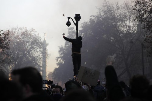 FILE - A protester uses a hammer to break a CCTV camera during a demonstration against a security law that would restrict sharing images of police, Saturday, Nov. 28, 2020 in Paris. A proposed French law for the 2024 Paris Olympics that critics contend will open the door for privacy busting video surveillance technology in France and elsewhere in Europe faces an important hurdle Tuesday March 28, 2023 with lawmakers set to vote on it. The bill would legalize the temporary use of so-called 