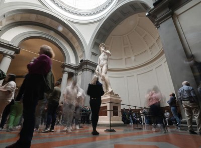 Tourists take photos in front of Michelangelo's 
