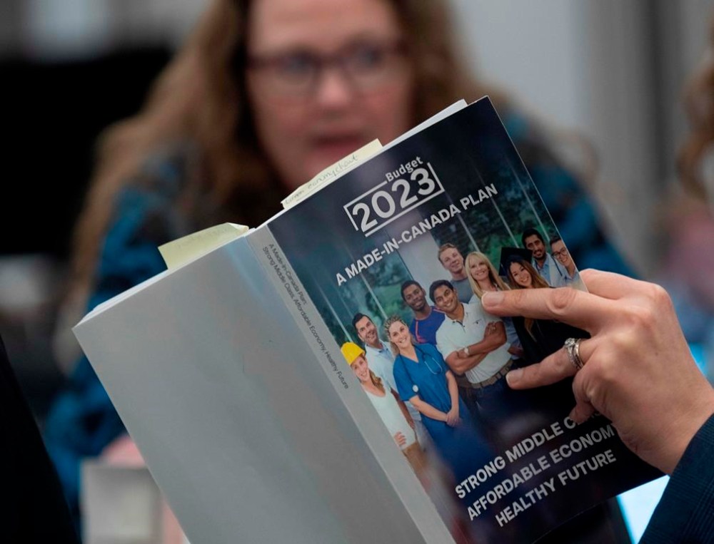 A reporter reads a copy of the Federal Budget in the lockup for the Federal budget, Tuesday, March 28, 2023 in Ottawa. THE CANADIAN PRESS/Adrian Wyld