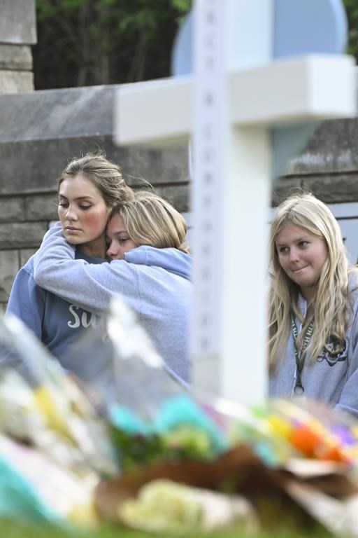 Students at a nearby school pay respects at a memorial for the people who were killed, at an entry to Covenant School, Tuesday, March 28, 2023, in Nashville, Tenn. Six people were killed at the private school and church yesterday by a shooter. (AP Photo/John Amis)