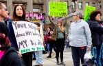 FILE - Boise, Idaho, resident Autumn Myers holds a sign with the Republican Party elephant symbol inside the outline of a uterus that reads, 