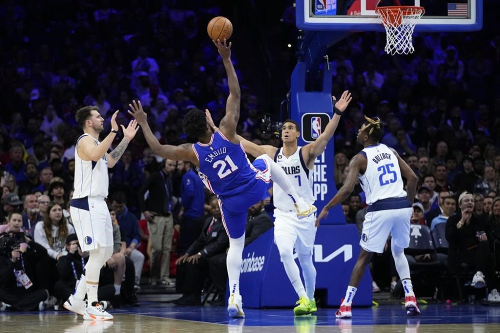 Philadelphia 76ers' Joel Embiid (21) goes up for a shot against Dallas Mavericks' Dwight Powell (7) during the first half of an NBA basketball game, Wednesday, March 29, 2023, in Philadelphia. (AP Photo/Matt Slocum)