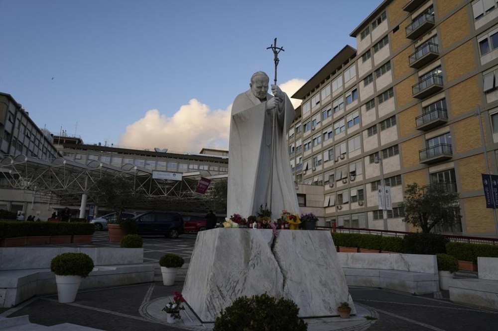 A statue of late Pope St. John Paul II is backdropped by the Agostino Gemelli hospital in Rome, Wednesday, March 29, 2023, after The Vatican said Pope Francis has been taken there in the afternoon for some scheduled tests. The Vatican provided no details, including how long the 86-year-old pope would remain at Gemelli University Hospital, where he underwent surgery in 2021. But his audiences through Friday were canceled, raising questions about Francis' participation during the Vatican's Holy Week activities starting Sunday.(AP Photo/Andrew Medichini)