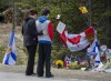 Visitors to a roadside memorial pays their respects in Portapique, N.S. on Friday, April 24, 2020. THE CANADIAN PRESS/Andrew Vaughan