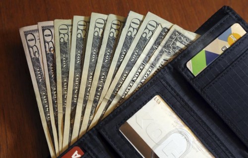 FILE - In this June 15, 2018, file photo, cash is fanned out from a wallet in North Andover, Mass. 