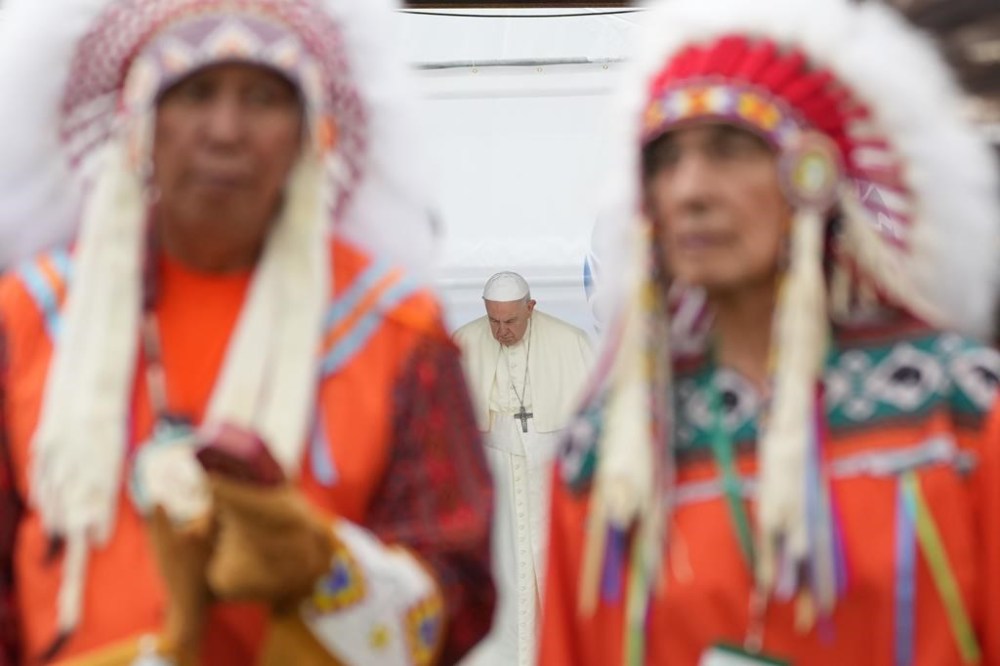 Pope Francis bows his head behind Indigenous chiefs preparing to perform a traditional dance at a ceremony in Maskwacis, Alta., on Monday, July 25, 2022. The Vatican has rejected the Doctrine of Discovery a year after Pope Francis met with Indigenous groups from Canada and delivered his first apology for the Catholic Church’s role in residential schools.THE CANADIAN PRESS/Nathan Denette