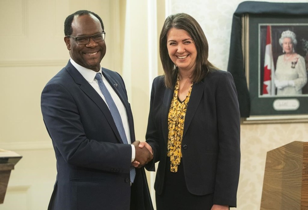 Kaycee Madu shakes hand with Alberta Premier Danielle Smith after he was sworn into cabinet in Edmonton, Monday, Oct. 24, 2022. Madu says it was appropriate for his boss to phone up a pastor charged over pandemic-rule protests and discuss the accused's upcoming criminal trial. THE CANADIAN PRESS/Jason Franson