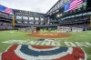 The Philadelphia Phillies and Texas Rangers stand for the national anthem before an opening day baseball game, Thursday, March 30, 2023, in Arlington, Texas. (AP Photo/Jeffrey McWhorter)