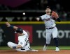 Cleveland Guardians second baseman Andres Gimenez makes the throw to first base for a double play after putting out Seattle Mariners' Cal Raleigh on a ball hit by Eugenio Suarez during the fourth inning of an opening day baseball game Thursday, March 30, 2023, in Seattle. (AP Photo/Lindsey Wasson)
